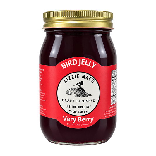 A glass jar of Lizzie Mae's Very Berry Bird Jelly with a gold metal lid and a red label, shown on a plain white background.